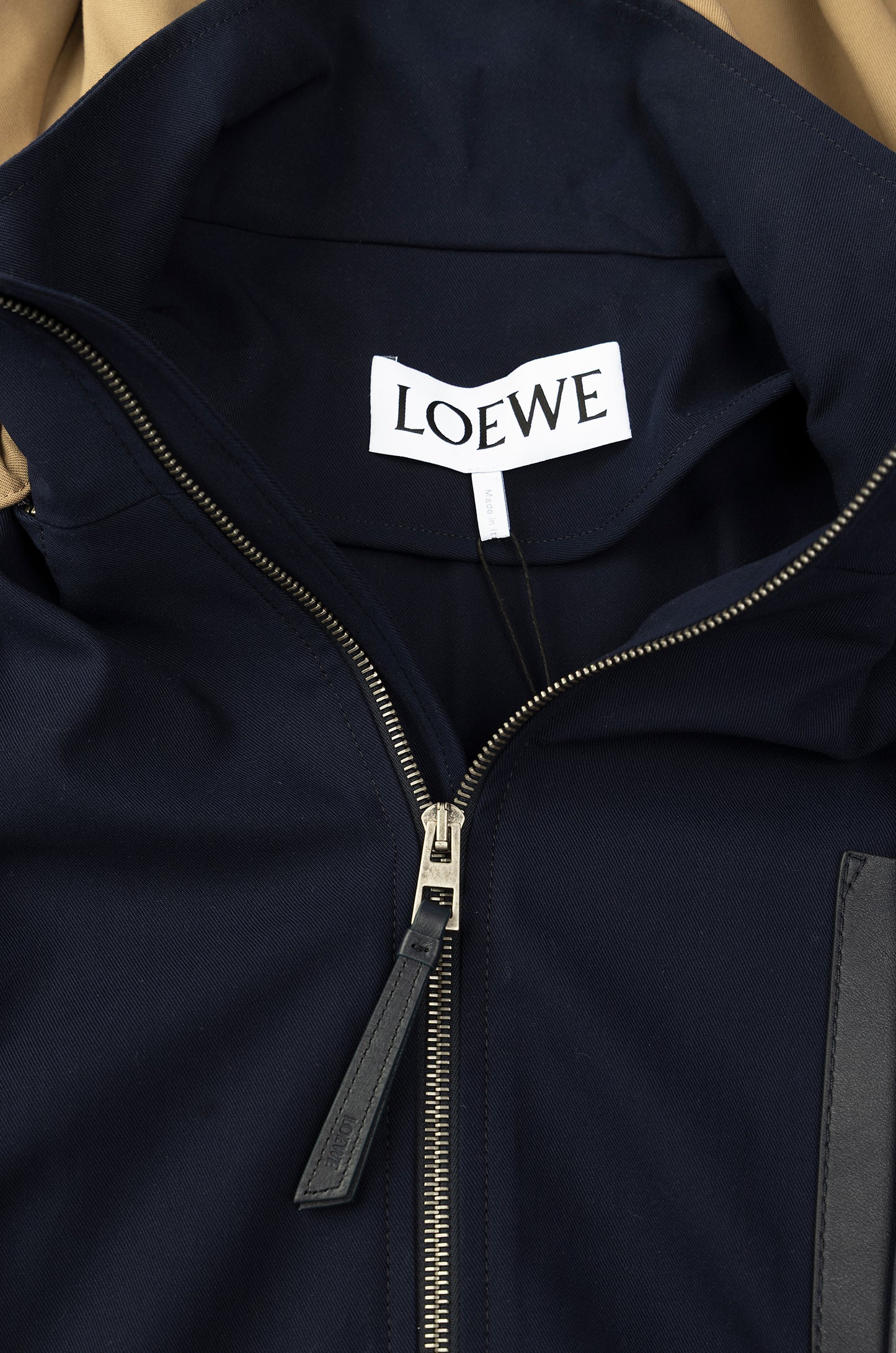 Navy blue jacket with Loewe logo on a beige background