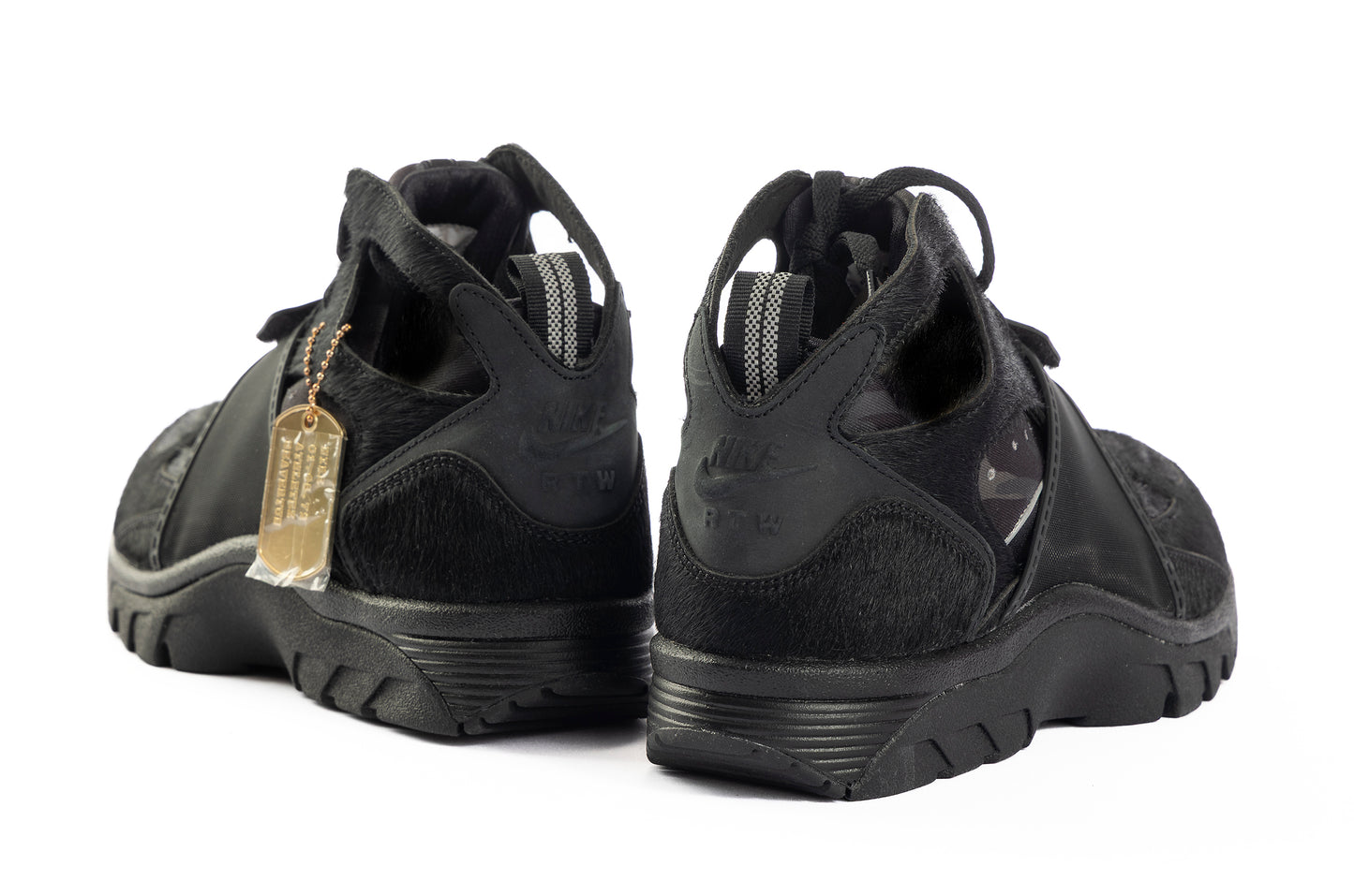 Black athletic shoes with a gold tag on a white background