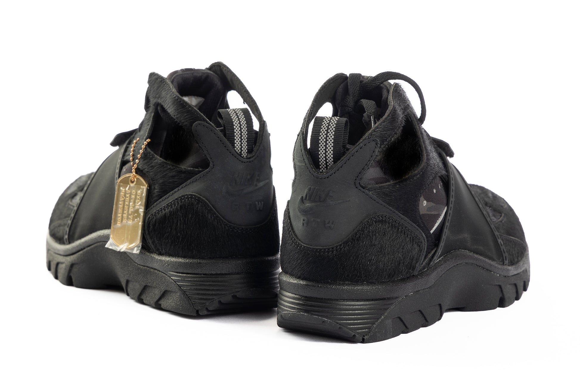 Black athletic shoes with a gold tag on a white background